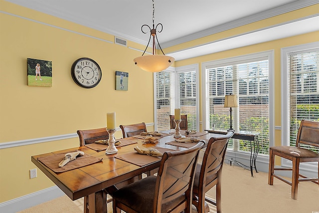 dining area featuring ornamental molding and light carpet