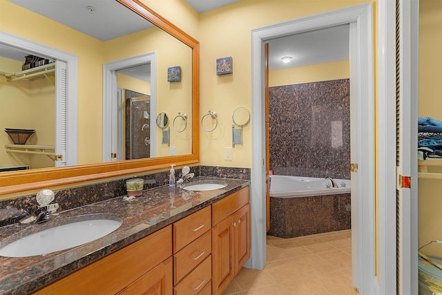 bathroom featuring vanity, tile patterned floors, and tiled bath