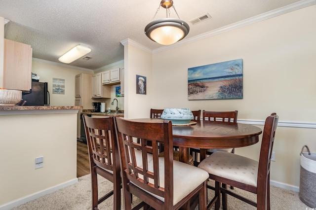 carpeted dining space featuring sink, crown molding, and a textured ceiling