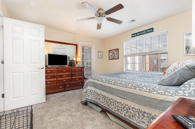 bedroom with light carpet, a textured ceiling, and ceiling fan