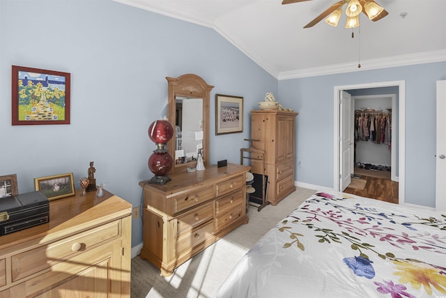 bedroom featuring ceiling fan, ornamental molding, vaulted ceiling, and a closet