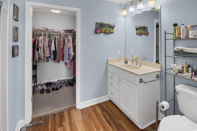 bathroom with hardwood / wood-style flooring, vanity, and toilet