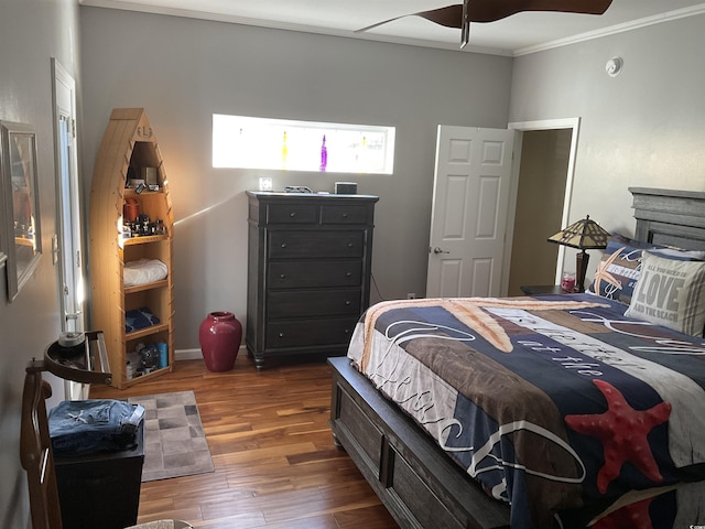 bedroom featuring dark wood-type flooring, ceiling fan, and ornamental molding