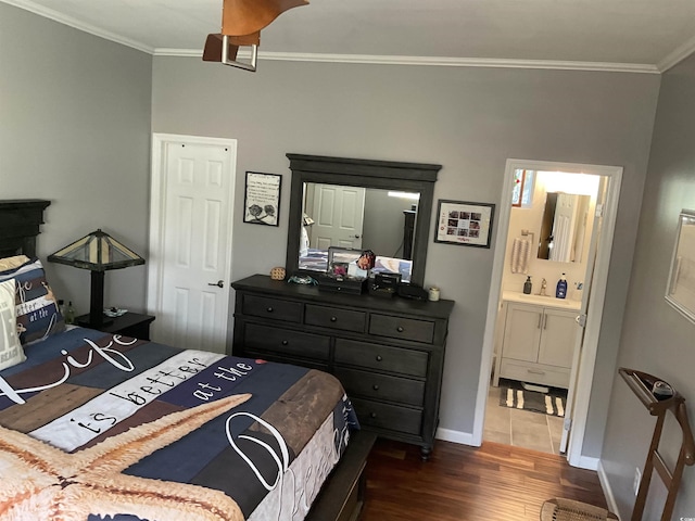 bedroom featuring ornamental molding, dark wood-type flooring, and ensuite bathroom