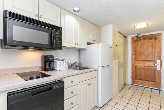 9550 Shore Dr Unit 722, Myrtle Beach, SC 29572 - kitchen featuring sink, white cabinets, light tile patterned floors, black appliances, and a textured ceiling