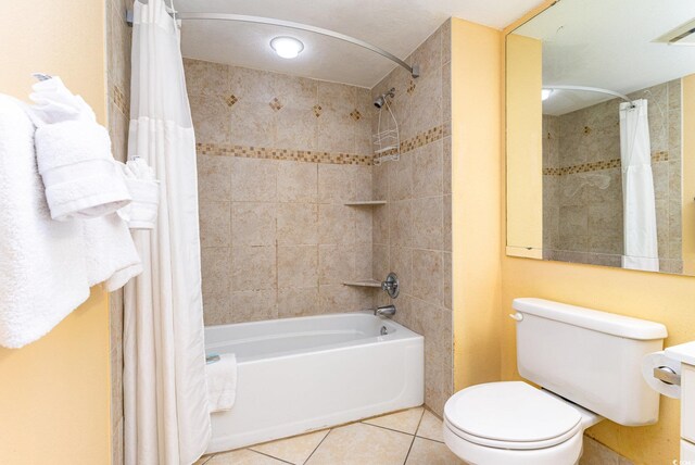 bathroom with shower / bathtub combination with curtain, tile patterned floors, and toilet