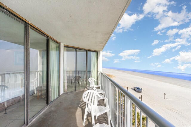 balcony with a beach view and a water view