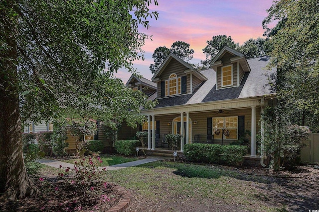 view of front of house with covered porch and a lawn