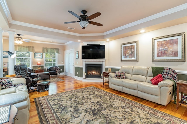 living room featuring crown molding, ceiling fan, and light hardwood / wood-style floors