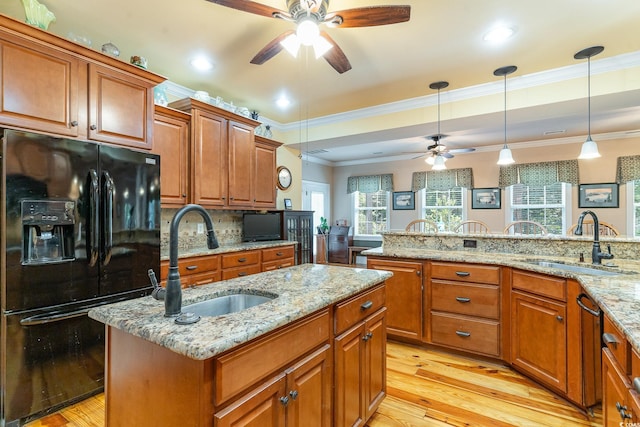 kitchen featuring a center island, black fridge, sink, and decorative light fixtures