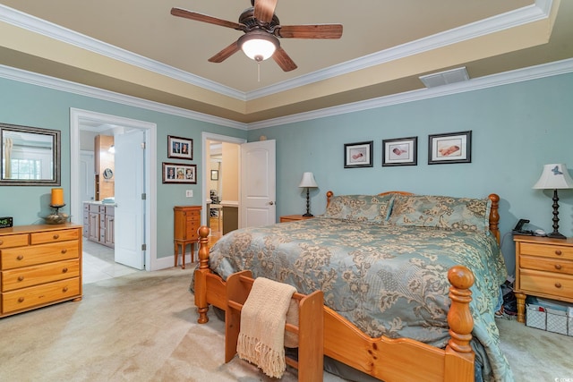 bedroom featuring ensuite bathroom, crown molding, light carpet, a raised ceiling, and ceiling fan