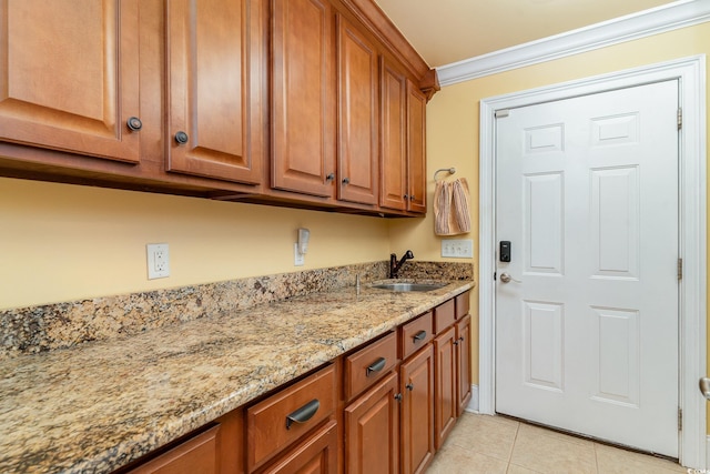 interior space with crown molding, sink, and light tile patterned floors