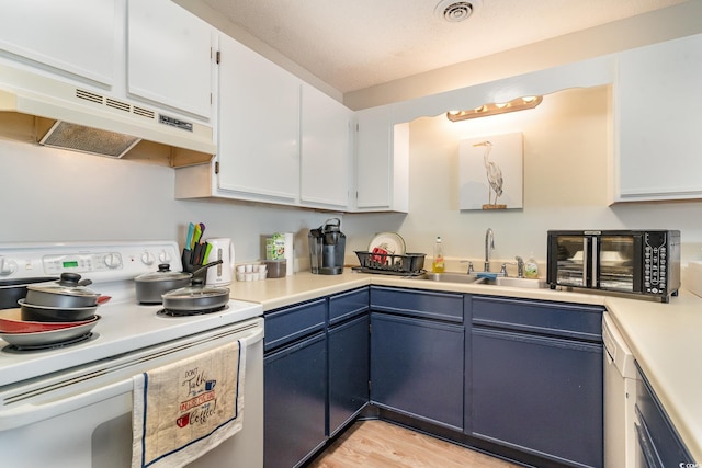 kitchen with electric range, blue cabinetry, and white cabinets