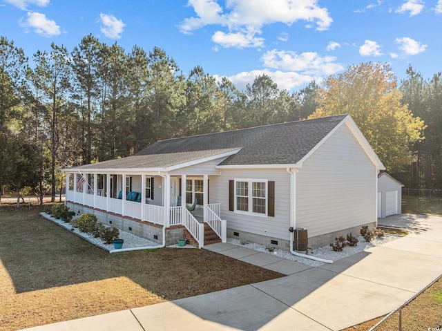 view of front of house featuring an outbuilding, a garage, a front lawn, and covered porch