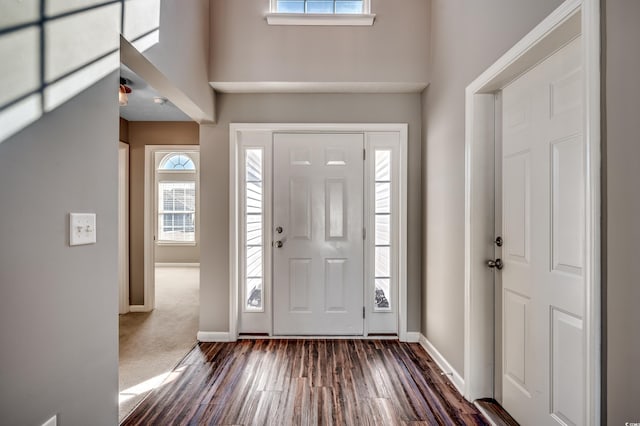 entrance foyer featuring dark colored carpet