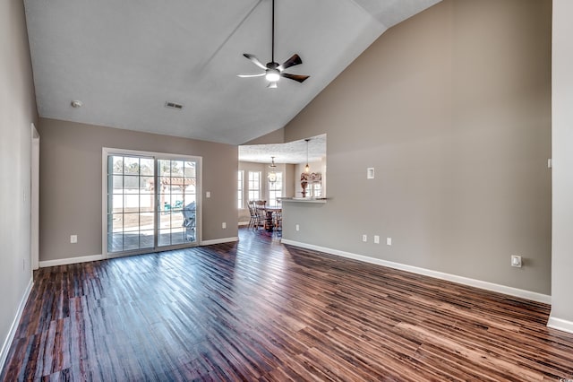 unfurnished living room featuring ceiling fan with notable chandelier, high vaulted ceiling, and hardwood / wood-style floors