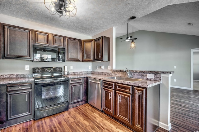 kitchen featuring vaulted ceiling, black appliances, wood-type flooring, sink, and kitchen peninsula