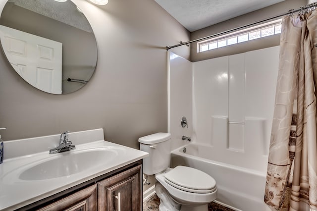 full bathroom with vanity, shower / bath combo, toilet, and a textured ceiling