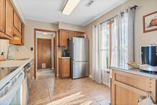 kitchen with stainless steel appliances, sink, and light tile patterned floors