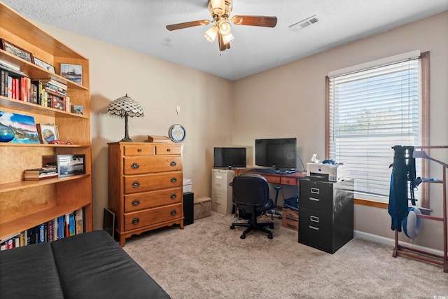 carpeted office featuring a textured ceiling and ceiling fan