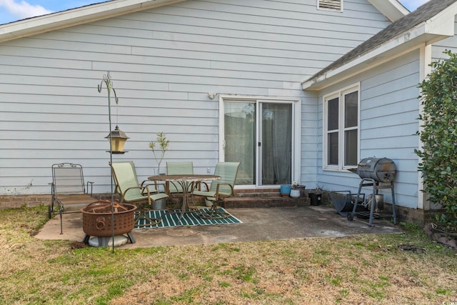 rear view of house with a patio area, a fire pit, and a lawn