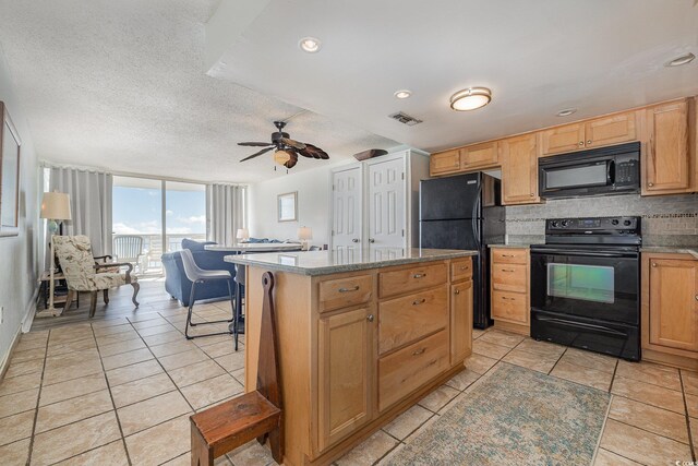 kitchen with a kitchen island, tasteful backsplash, light tile patterned floors, black appliances, and a textured ceiling