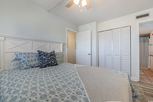 bedroom with hardwood / wood-style floors, ceiling fan, and a closet