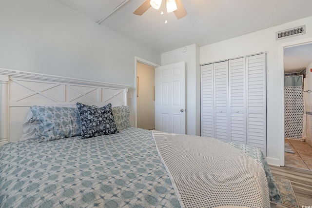 bedroom with light wood-type flooring, a closet, visible vents, and ceiling fan