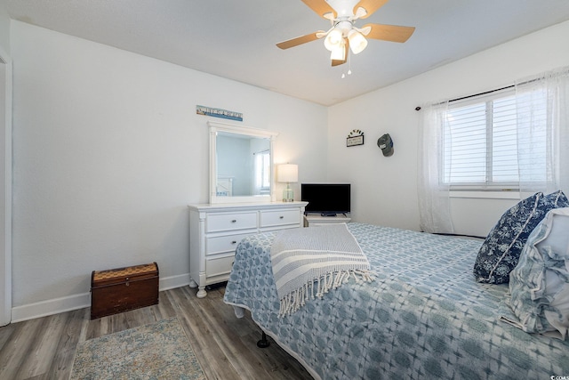 bedroom featuring ceiling fan, baseboards, and wood finished floors