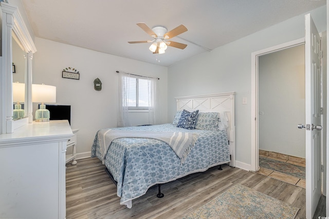 bedroom with a ceiling fan, baseboards, and wood finished floors