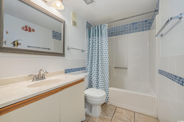 full bathroom with tile walls, vanity, shower / tub combo, toilet, and a textured ceiling