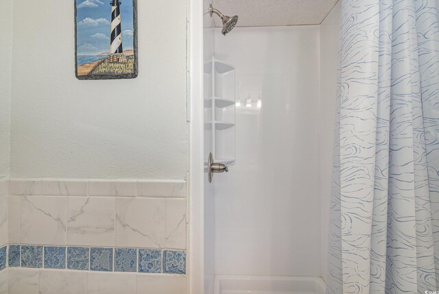 bathroom with walk in shower and a textured ceiling