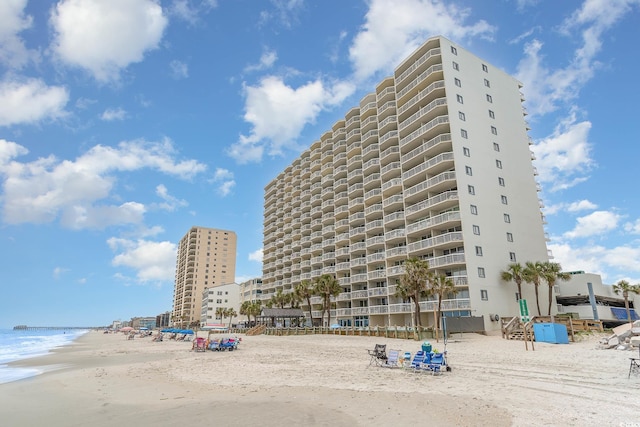 view of building exterior with a water view and a view of the beach