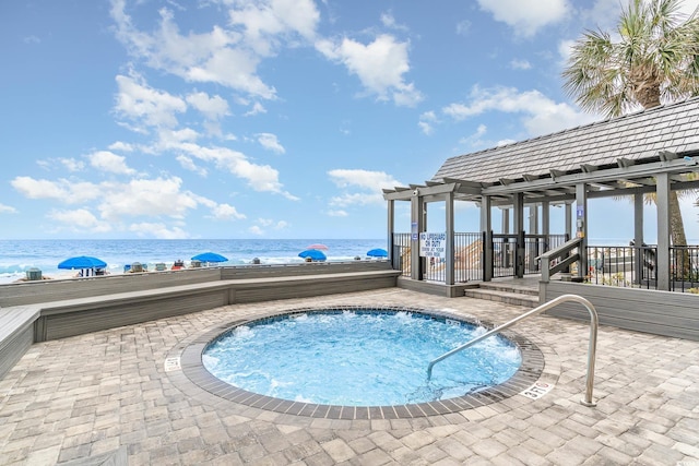 view of swimming pool with a pergola, a hot tub, and a water view