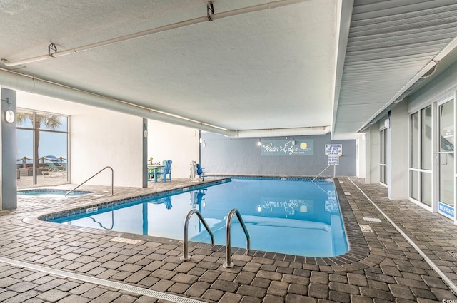 community pool featuring a patio area and an indoor in ground hot tub