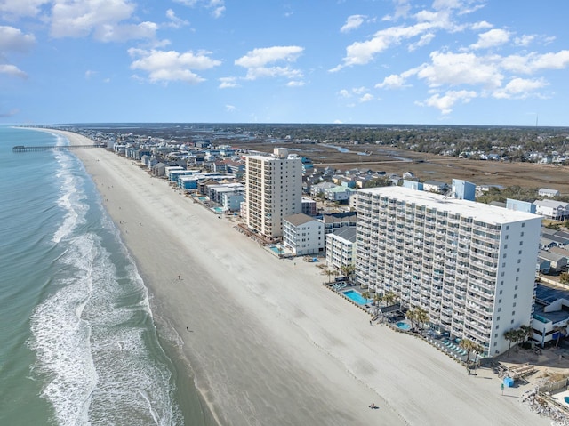 birds eye view of property featuring a water view, a beach view, and a city view