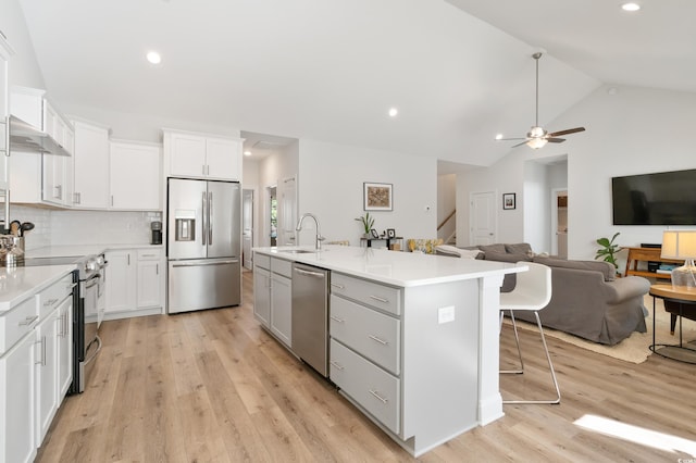 kitchen featuring white cabinetry, appliances with stainless steel finishes, sink, and a center island with sink