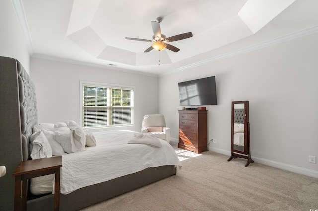 bedroom featuring light carpet, a tray ceiling, ornamental molding, and ceiling fan