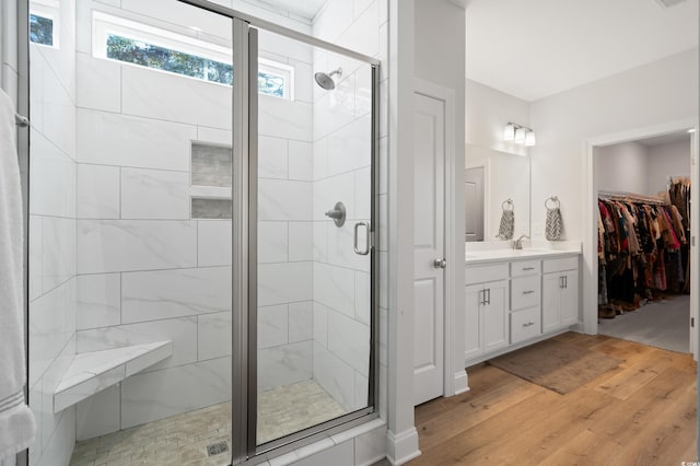 bathroom featuring vanity, hardwood / wood-style flooring, and a shower with shower door