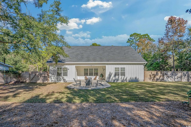 back of house with a yard and a patio