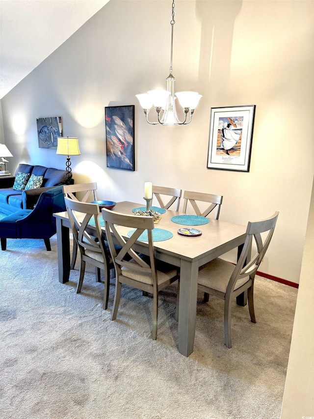 dining area with carpet floors, high vaulted ceiling, and a chandelier