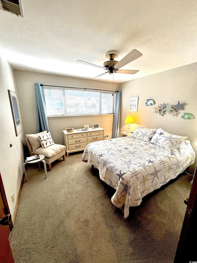 bedroom featuring ceiling fan, carpet floors, and a textured ceiling