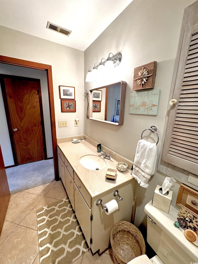 bathroom featuring vanity, toilet, and tile patterned flooring