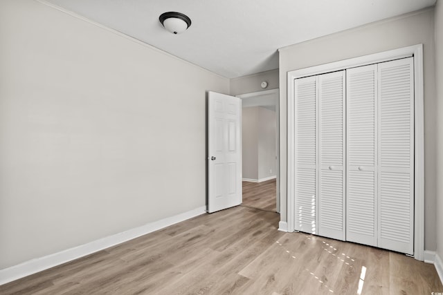 unfurnished bedroom with light hardwood / wood-style floors and a closet