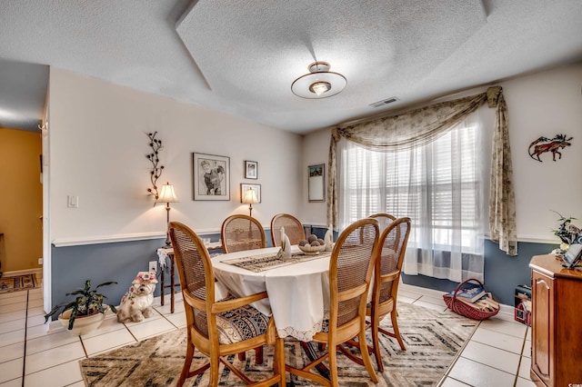 1579 Southwood Dr, Surfside Beach, SC 29575 - dining room with light tile patterned flooring, a textured ceiling, and baseboards