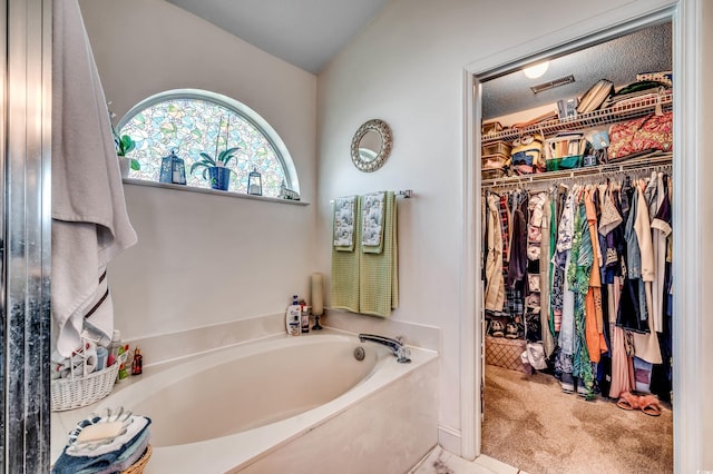 1579 Southwood Dr, Surfside Beach, SC 29575 - bathroom with a spacious closet, a bath, and vaulted ceiling