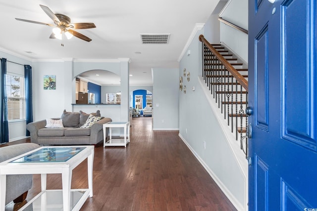 foyer with ornamental molding, dark wood-type flooring, and ceiling fan