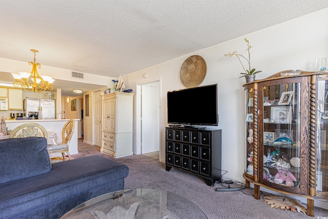 carpeted living room with a chandelier and a textured ceiling