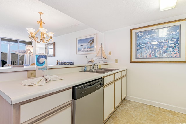 kitchen featuring sink, decorative light fixtures, a textured ceiling, stainless steel dishwasher, and kitchen peninsula