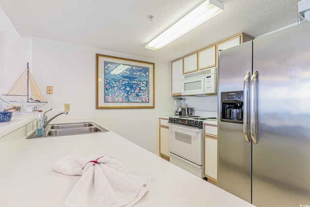 kitchen with white appliances, sink, and a textured ceiling